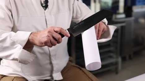 chef demonstrating knife skills on paper