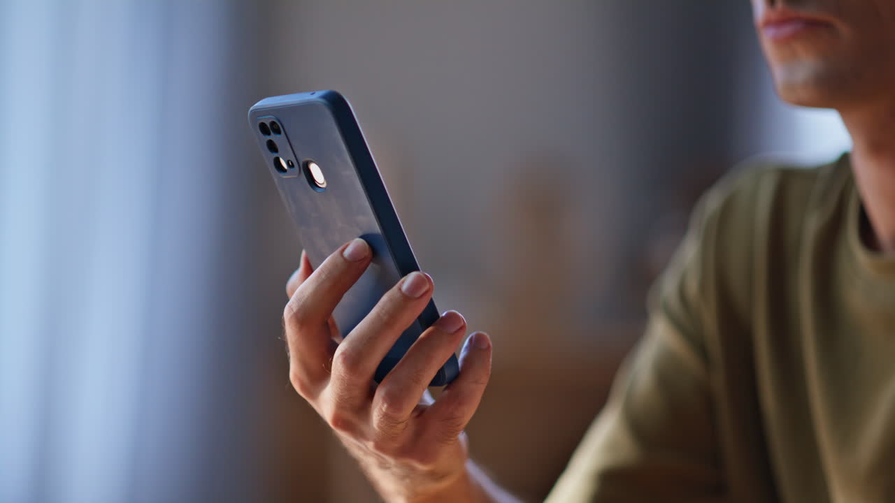 Man hands holding mobile phone relaxing home closeup. Unknown freelancer online