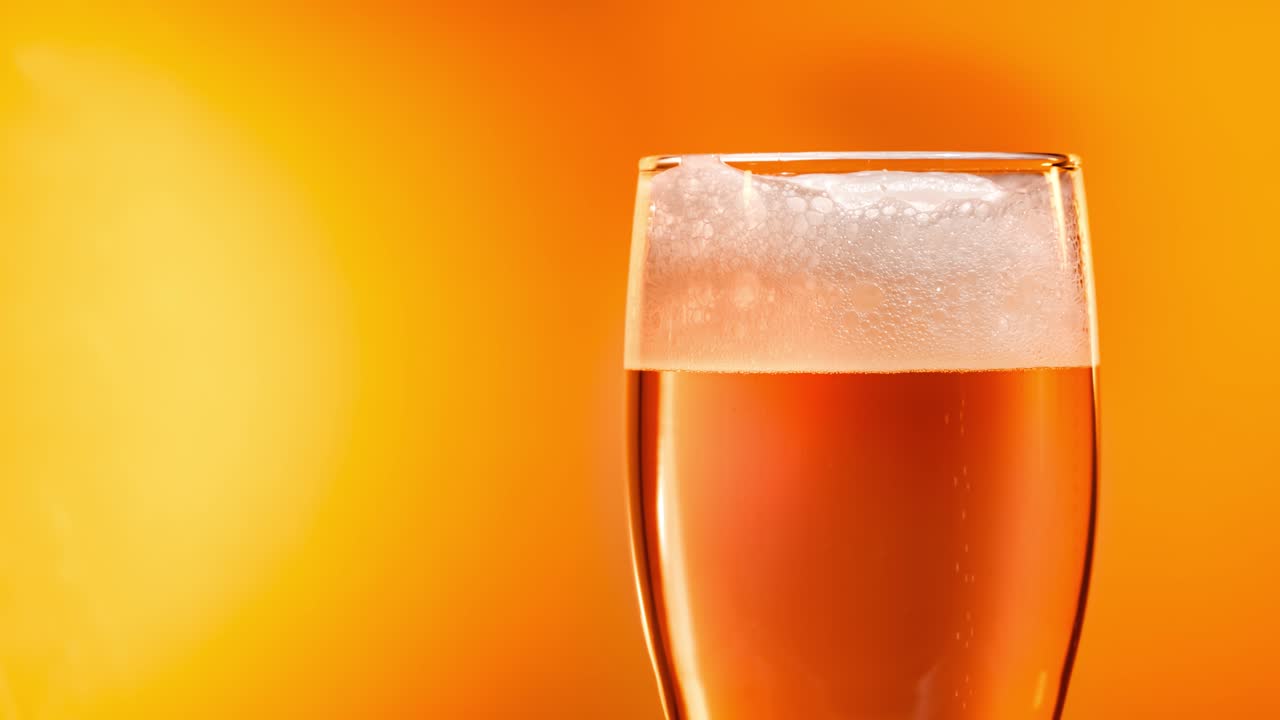 la cerveza lager se asienta en el vaso con una tapa blanca de espuma
