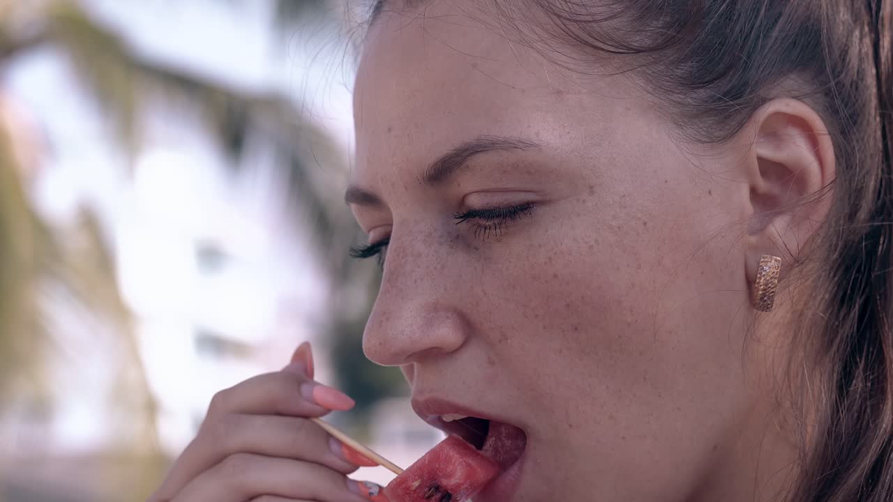 la dama con pecas y pendientes de oro come sandía.