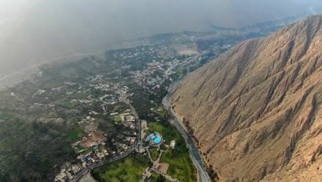 flying over santa eulalia town between steep mountains in huarochiri, peru