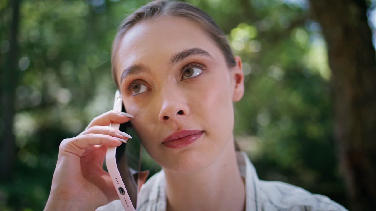 Serious woman have phone conversation in park close up. Girl talking smartphone