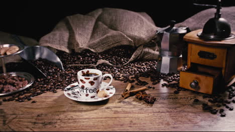 camera is pushing back and revealing a freshly poured espresso cup with cinnamon, star anise and freshly roasted coffee beans on a wooden table