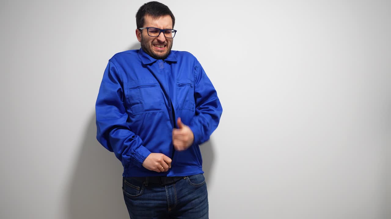 길고 힘든 하루가 지난 후 기계장치의 파란 재을 벗고 있는 남자