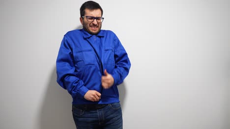 uomo che si toglie la giacca blu meccanica dopo una lunga e dura giornata di lavoro