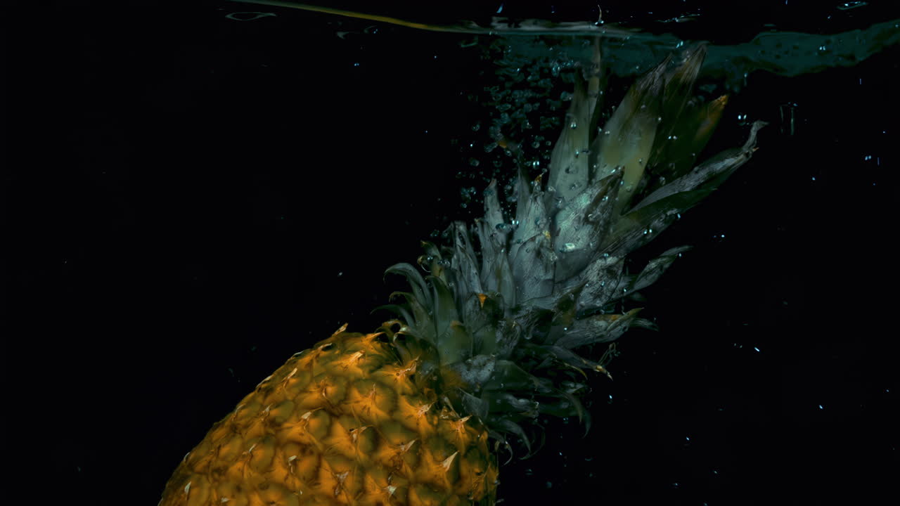 Pineapple in slow motion falling in the water