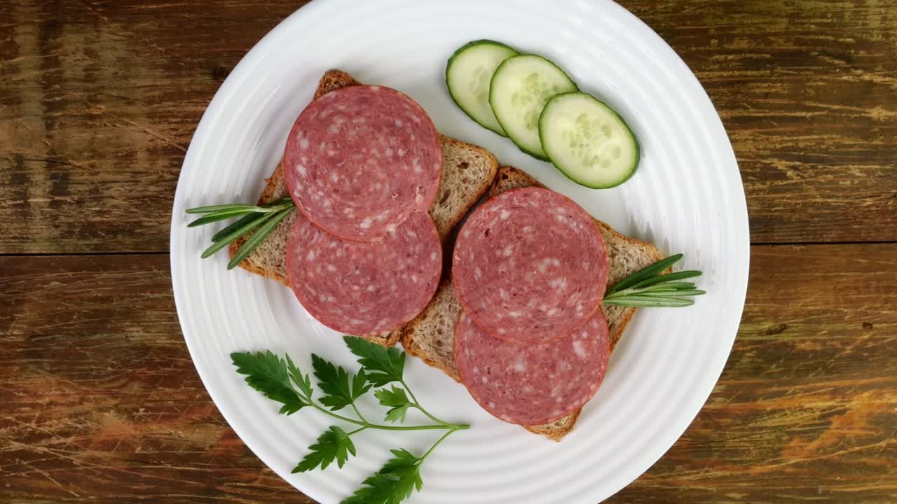 접시에, 호박, 파슬리와 함께 살라미 샌드위치를 열고 천천히 회전합니다.