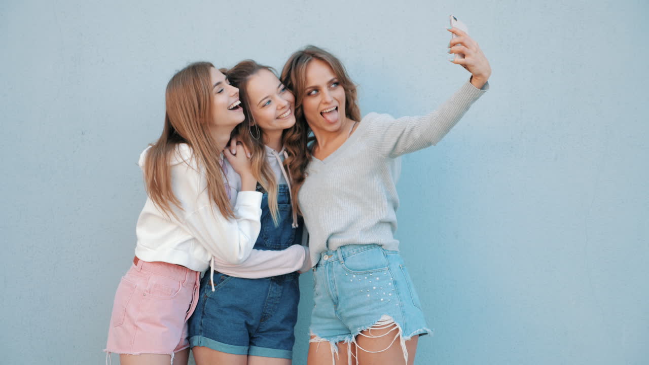 세 명의 친구들이 셀피를 찍고 있습니다.