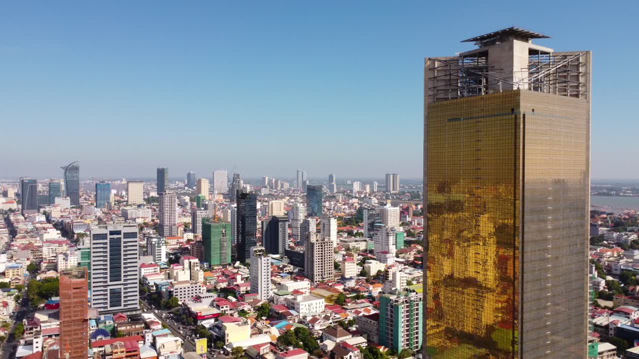un horizonte moderno de la ciudad con edificios altos y un rascacielos dorado a la luz del sol, vista aérea