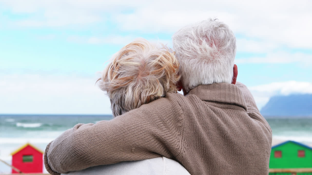 una pareja de mayores disfrutando juntos en la playa.