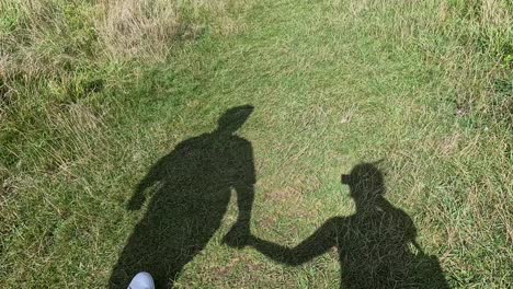 shadows of couple walking hand in hand