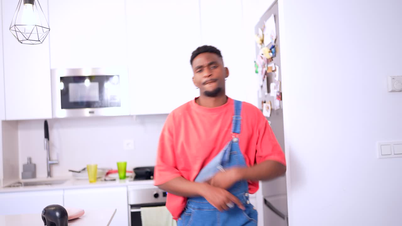 Man in overalls inside of a kitchen