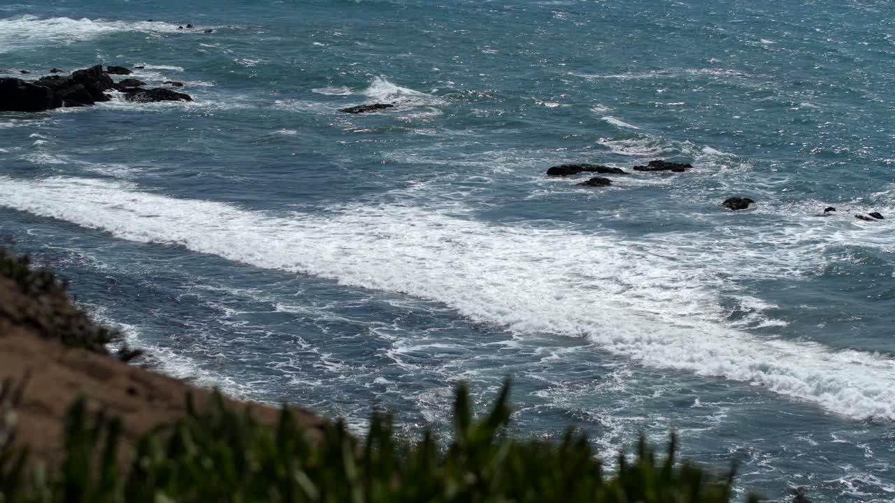 Onde che si infrangono su una spiaggia sotto una scogliera