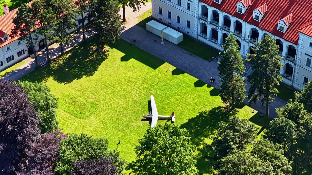 Aerial view of plane landed in yard of Biržai Castle in Lithuania on summer day