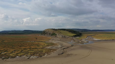 Aerial-shot-over-a-bay-on-the-English-coast-line-when-the-tide-is-out,-on-bright-sunny-day