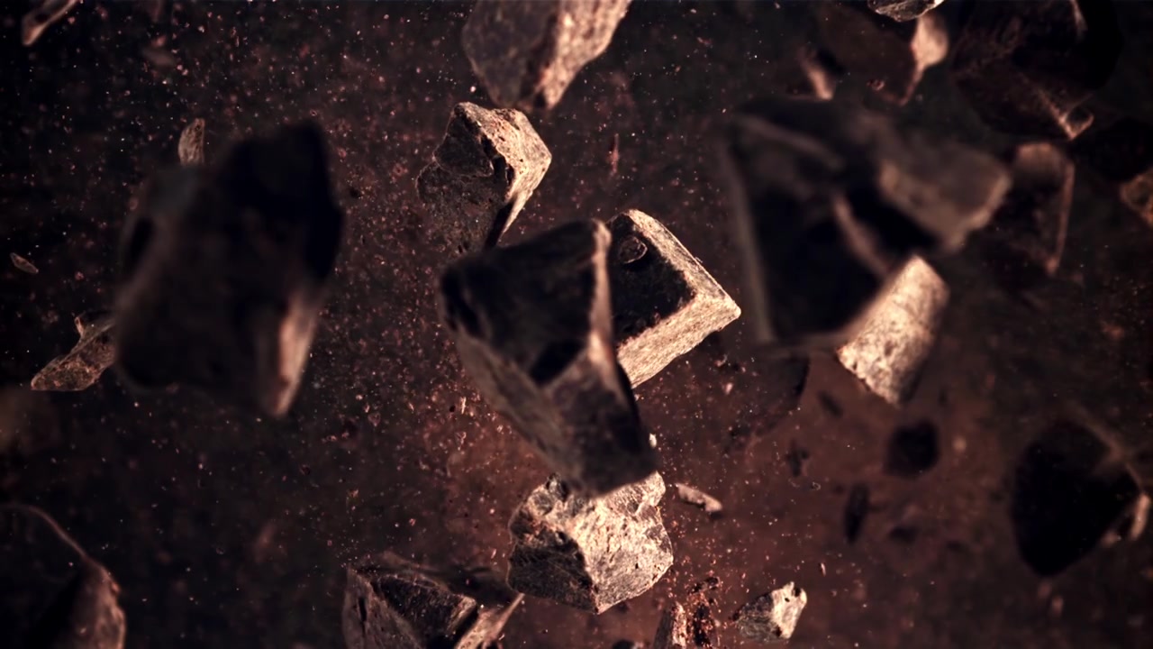 Pedaços de chocolate amargo caindo com cacau em pó em câmera lenta.