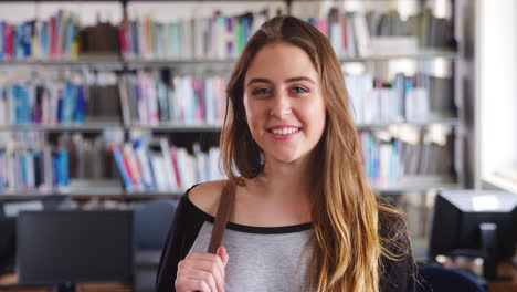 retrato de una estudiante de pie en la biblioteca de la universidad
