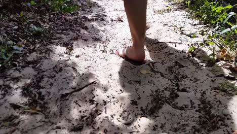 Siguiendo-Los-Pies-De-Una-Mujer-En-La-Arena-De-La-Playa-Caminando-Por-Un-Bosque-En-Cámara-Lenta