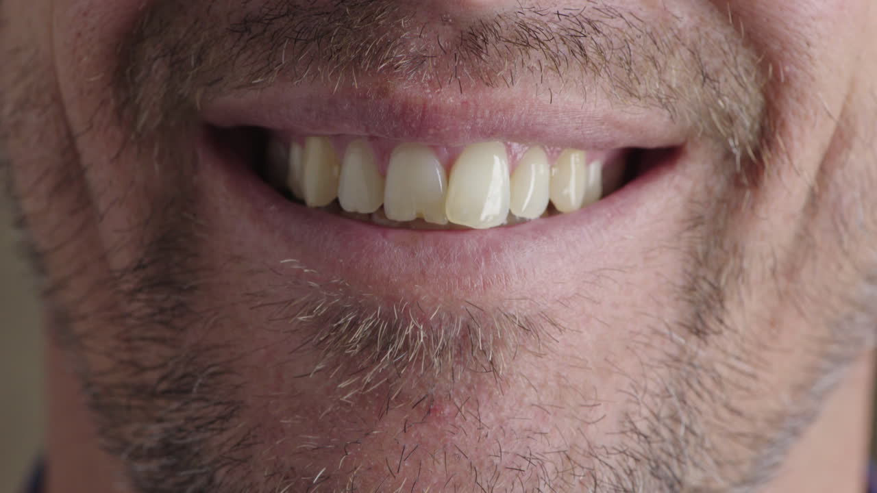 hombre caucásico boca sonriendo dientes felices con pelo facial sin afeitar rastrojo expresión alegre de cerca