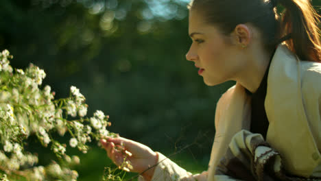 woman admiring flowers in a park