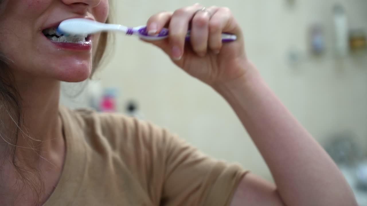 Close up of a woman brushing her teeth in the morning