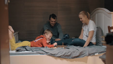 Familia-Jugando-Un-Divertido-Juego-De-Ajedrez-En-El-Dormitorio