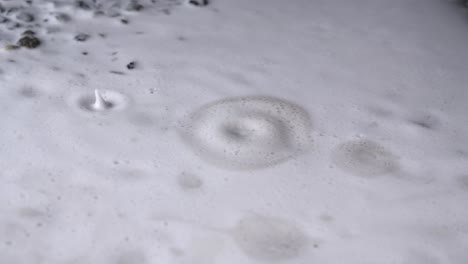 water drops on foamy puddle on ground