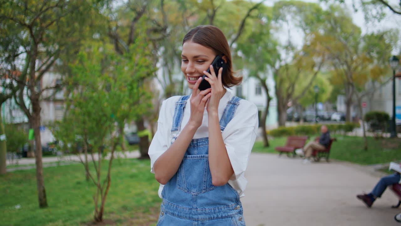 Carefree lady chatting smartphone walking city park closeup. Woman talking