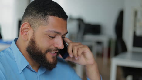 una foto de cerca de un joven guapo hablando por teléfono.