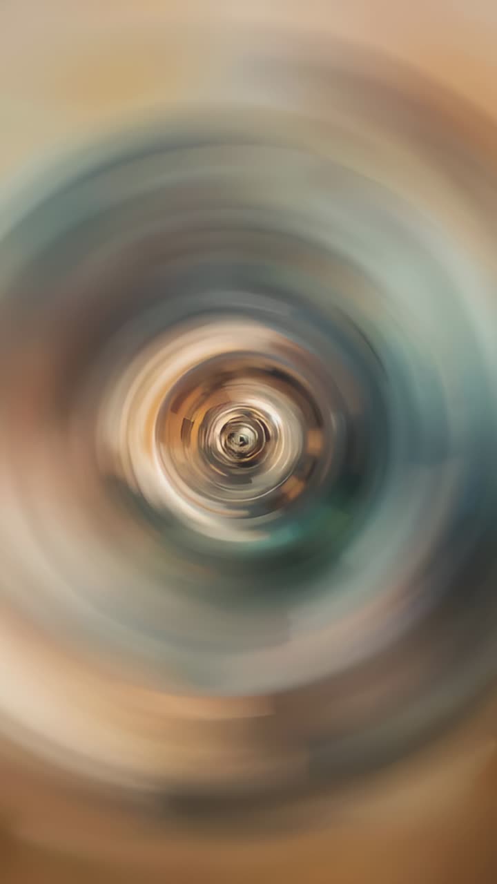 Vertical video: Playback showing central vortex rotating subtly on loop core beige or teal radial bl
