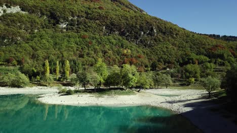 Mountain-blue-water-lake-in-Italian-Alps-Dolomites-with-trees-and-peaks-with-a-small-island-drone-aerial