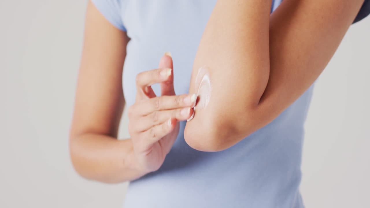 video de una mujer biracial tocando su brazo sobre un fondo blanco