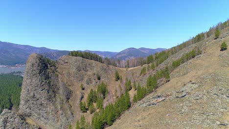 aerial view of a mountain range with green trees and blue sky