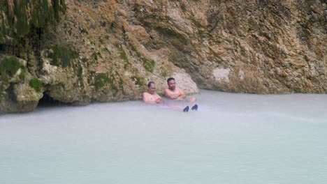 Visitors cooling off under a small waterfall