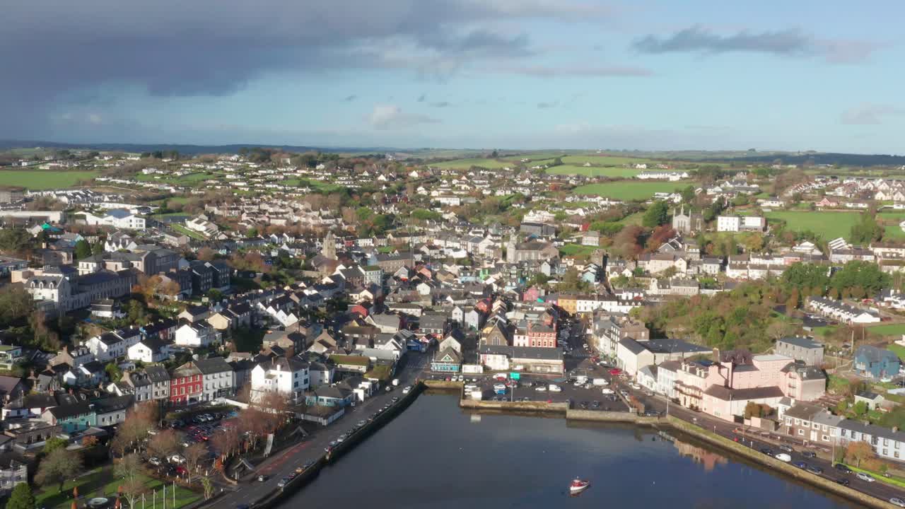 una toma aérea inclinándose hacia abajo en la pintoresca ciudad de kinsale, irlanda mostrando su puerto y el río brandon