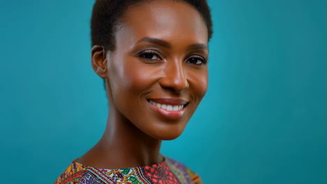 portrait of a smiling woman with short hair against a teal background