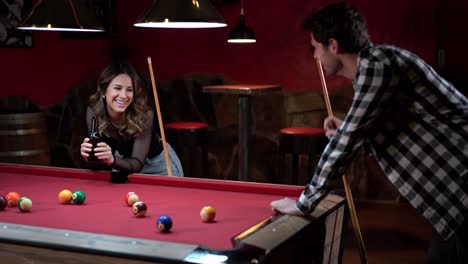 Happy-couple-playing-billiards-in-pub