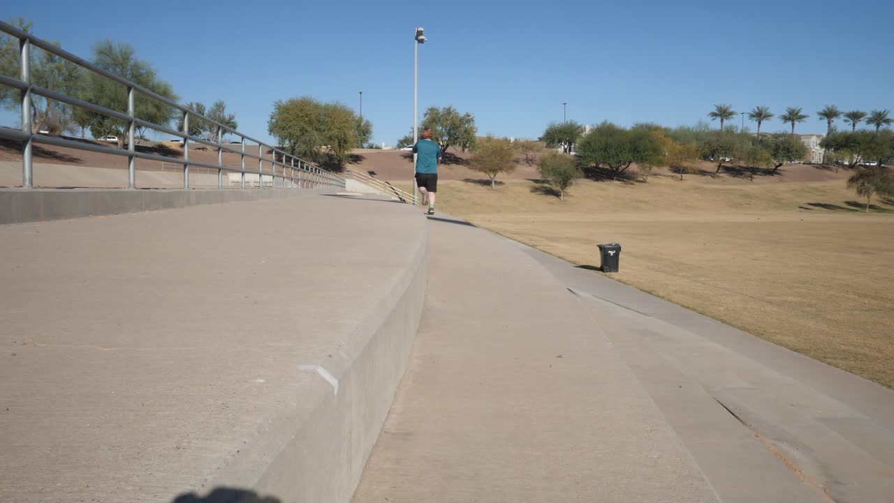 Red hair runner running past camera in a park.