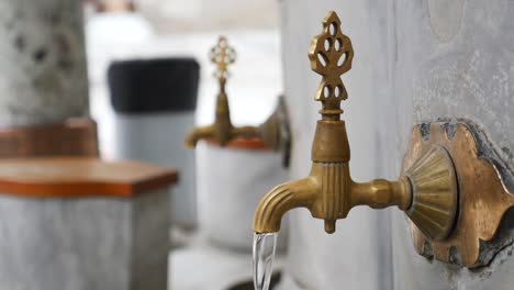 a traditional turkish water fountain with brass faucets