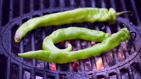 green-banana-peppers-on-outdoor-grill-closeup-showing-flames-and-smoke-with-copy-space