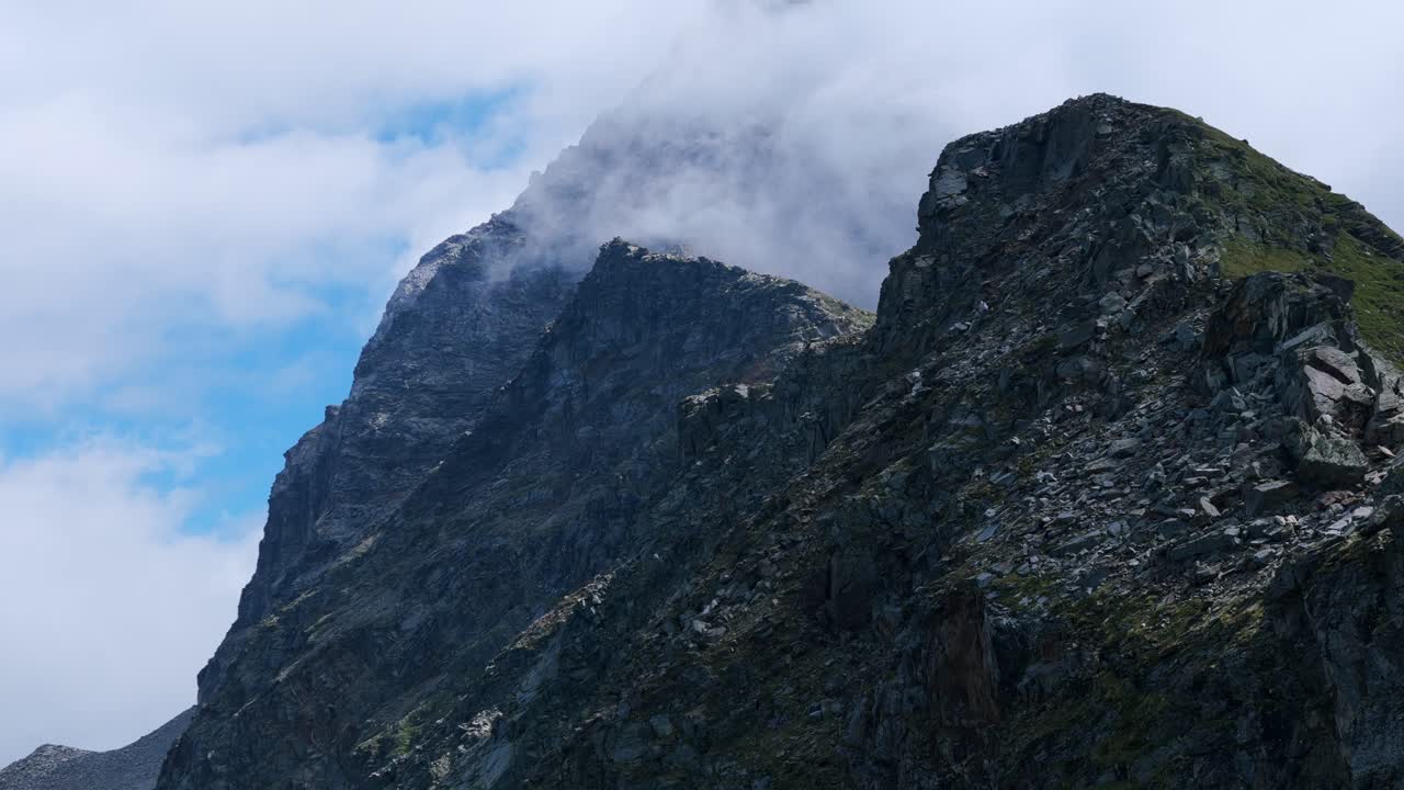impresionante vista de ángulo bajo de nubes sobre los picos de las montañas valmalenco en el norte de italia en la temporada de verano