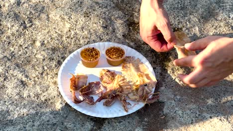 hands arranging food on a plate outdoors