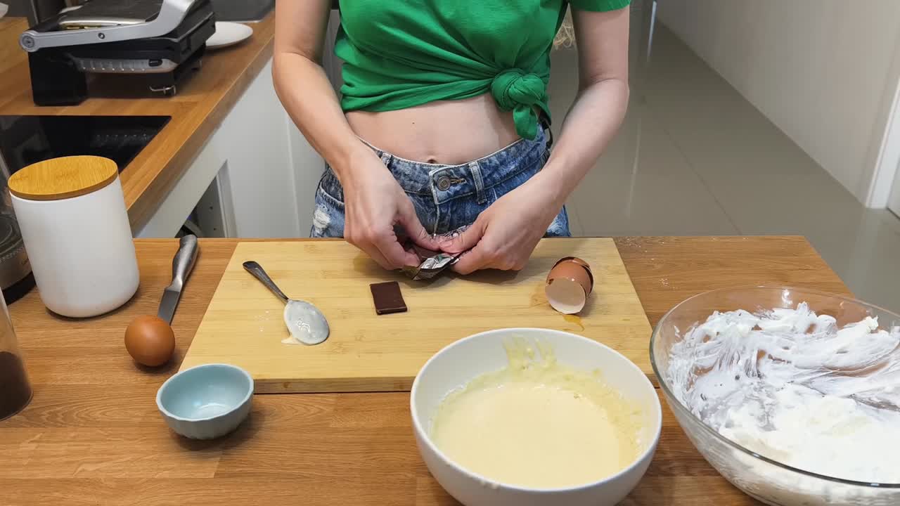 Woman preparing dessert with chocolate and cream in the kitchen