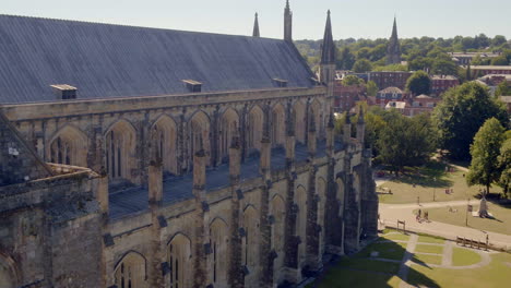 Rising-drone-rising-shot-of-Winchester-Cathedral-and-grounds,-filmed-in-Summer,-Hampshire,-UK