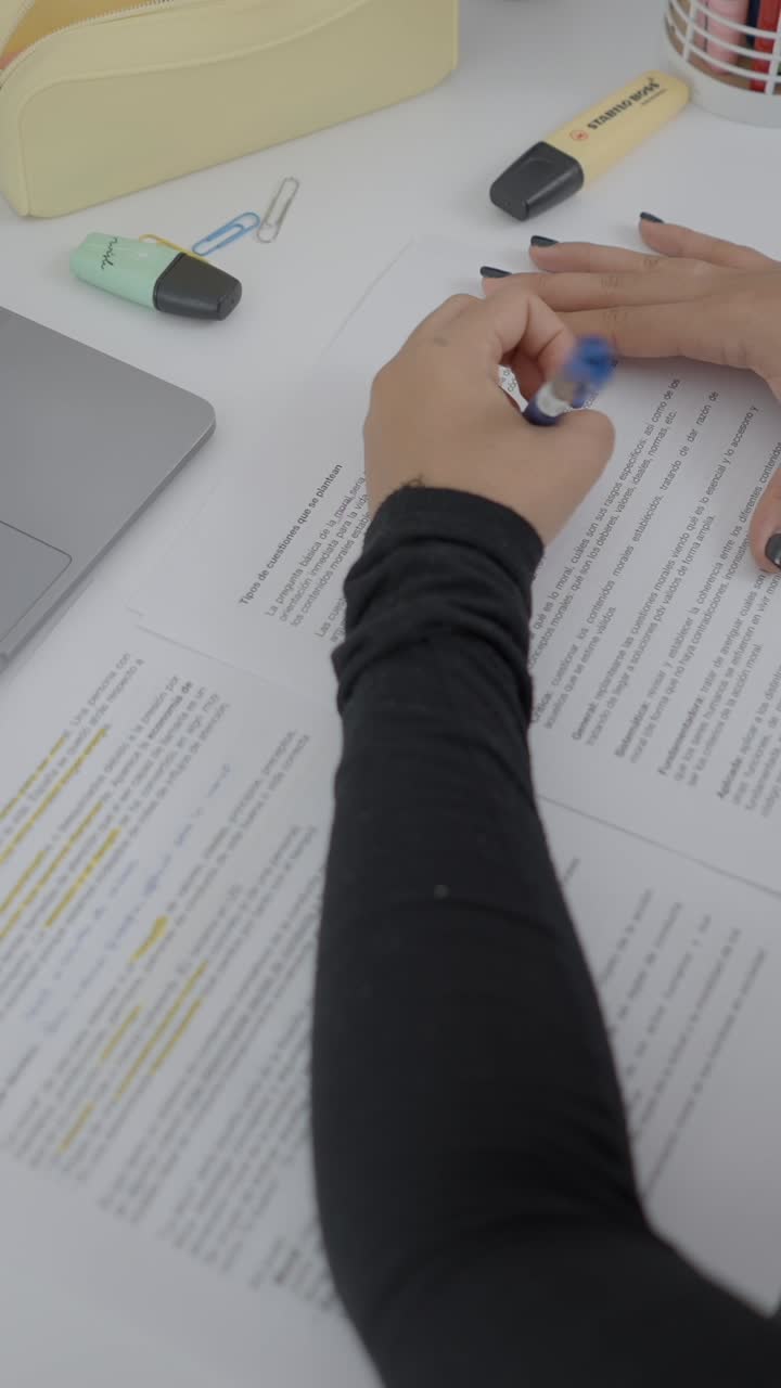 Person studying at a desk with notes and a laptop