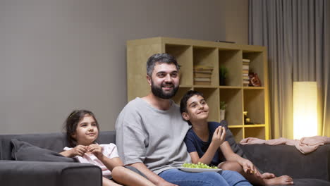 father, daughter and son in the living room at home