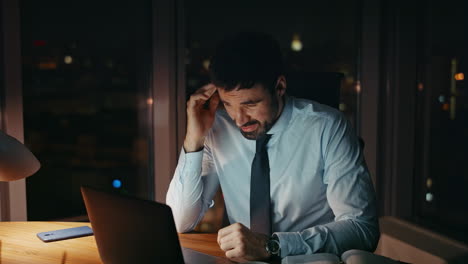 anxious office manager working on laptop late evening closeup. troubled employee