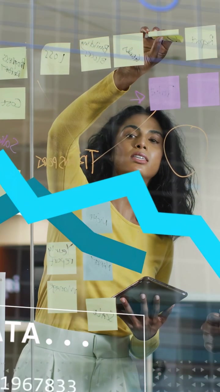 Vertical video: Woman using tablet, placing notes on glass and pulling data HUD charts for planning