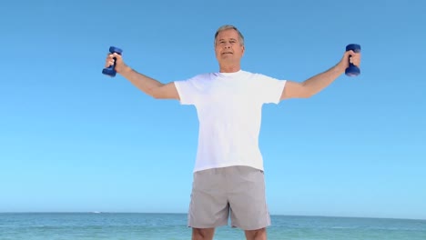 aged man working his muscles with dumbbells
