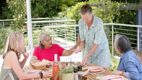 senior diverse group of women enjoy a meal outdoors